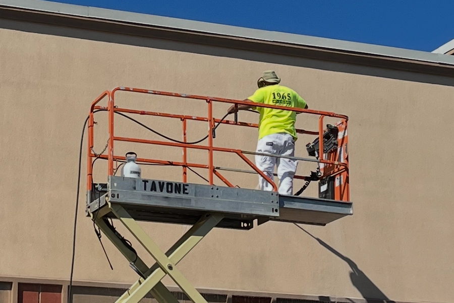 man on a lift power washing a building